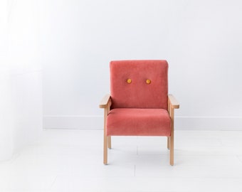 Un sillón color coral hecho a mano para habitación infantil.