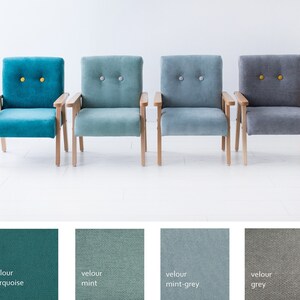 Peut inclure: Quatre fauteuils en velours turquoise, menthe, gris-menthe et gris. Chaque chaise a des bras et des pieds en bois clair. Les chaises turquoise et grises ont des boutons jaunes, tandis que les chaises menthe et gris-menthe ont des boutons gris.