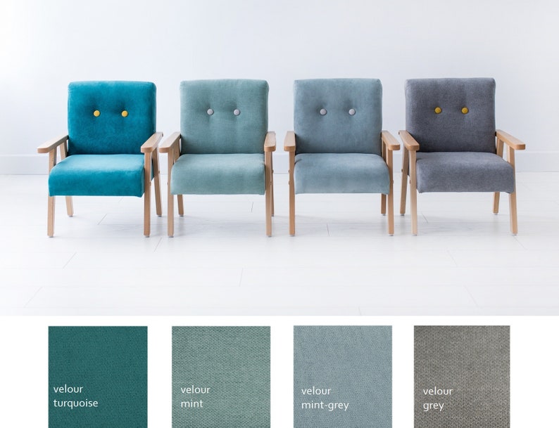 Peut inclure: Quatre fauteuils en velours turquoise, menthe, gris-menthe et gris. Chaque chaise a des bras et des pieds en bois clair. Les chaises turquoise et grises ont des boutons jaunes, tandis que les chaises menthe et gris-menthe ont des boutons gris.