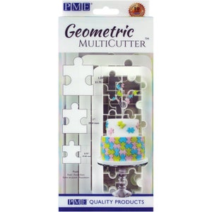 Puede incluir: Un cortador multi-formas de plástico blanco para hacer decoraciones de fondant o pasta de goma con forma de rompecabezas. El cortador incluye tres tamaños diferentes de piezas de rompecabezas: 1,9 cm, 2,5 cm y 3,2 cm. El paquete también muestra un pastel decorado con fondant con forma de rompecabezas.