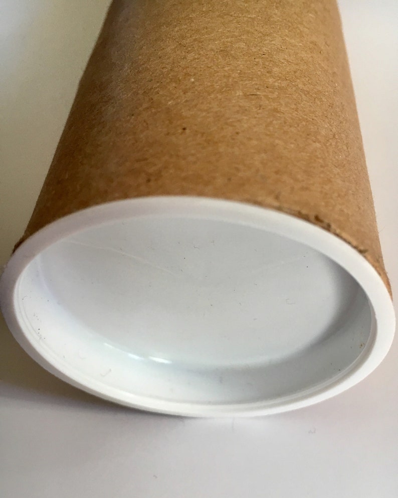 Puede incluir: Un tubo de cart&oacute;n marr&oacute;n con una tapa de pl&aacute;stico blanco. El tubo est&aacute; vac&iacute;o y la tapa es lisa.
