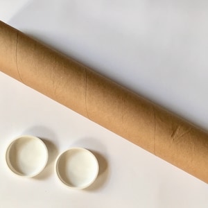 Puede incluir: Un tubo de env&iacute;o de cart&oacute;n marr&oacute;n con dos tapas de pl&aacute;stico blanco.