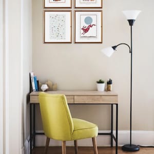 Various prints displayed on wall above a desk.