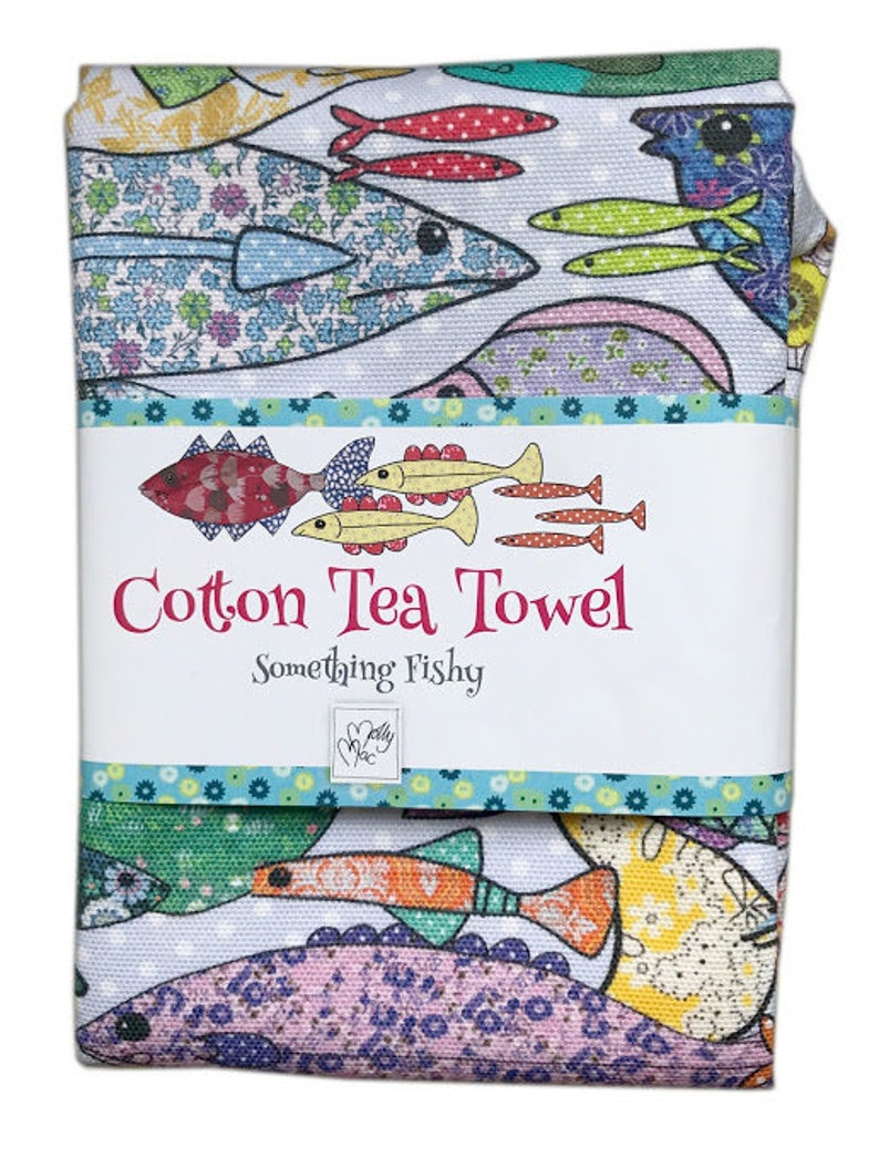 May include: A cotton tea towel with a colorful fish design. The towel has the text "Cotton Tea Towel" and "Something Fishy" printed on it.