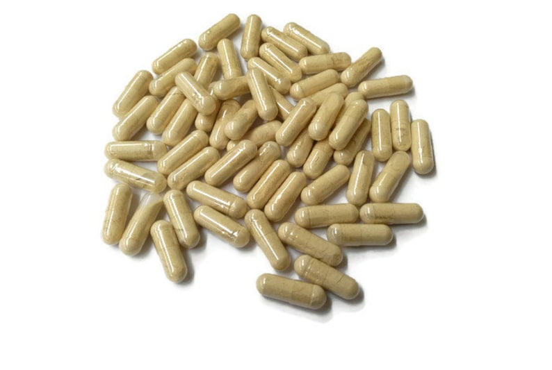 May include: A large pile of beige capsules, likely a dietary supplement, on a white background.