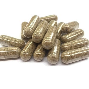 May include: A pile of brown capsules, likely herbal supplements, on a white background.