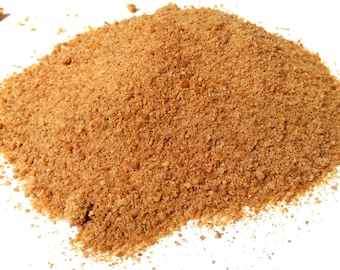 May include: A pile of light brown, granulated sugar against a white background. The sugar appears coarse and has a slightly uneven texture. The image is well-lit, highlighting the color and texture of the sugar.
