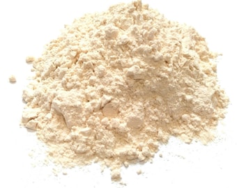 May include: A close-up of a pile of light beige flour on a white background.