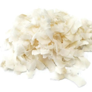 Puede incluir: Un montón de copos de coco rallado sin azúcar. El coco es blanco y tiene una textura ligeramente rugosa.