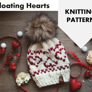 May include: White and red knitted hat with a pom pom on top. The hat has a pattern of red hearts on a white background. The hat is surrounded by red hearts, white flowers, and white beads. The text "Knitting Pattern" is visible in the upper right corner of the image.