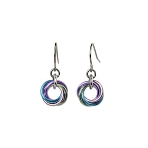 May include: A pair of silver dangle earrings with a multi-colored knot design. The knot is made of four intertwined rings in shades of blue, green, and purple.