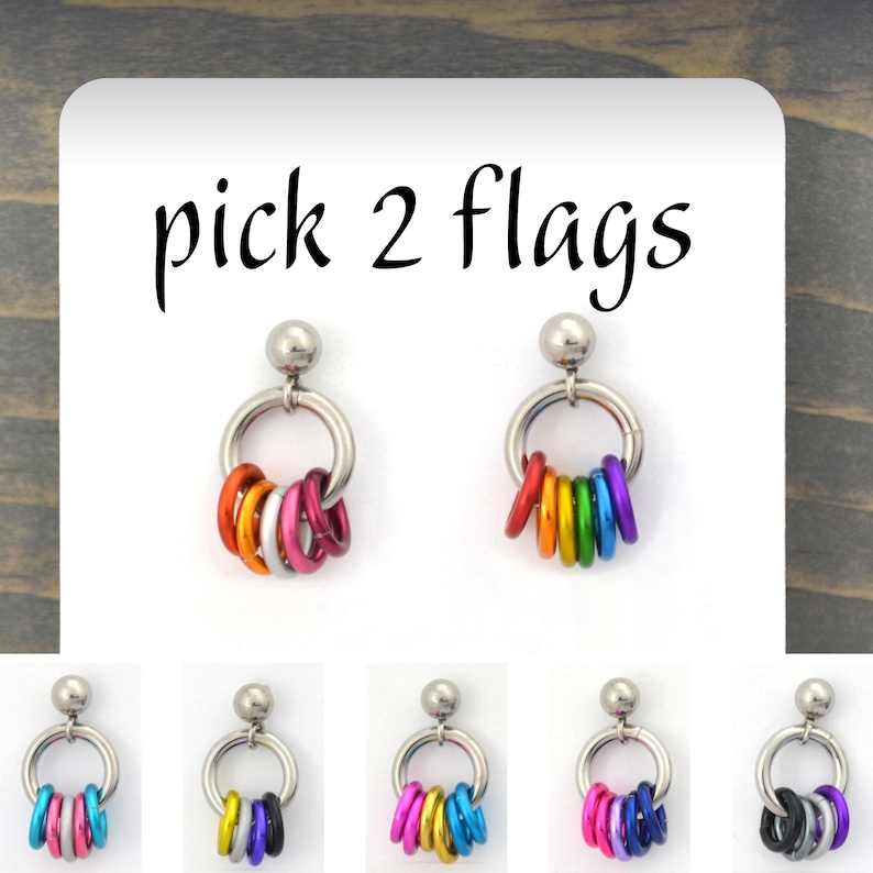 A pair of mismatch lgbtq pride chainmaille earrings with 5 single earrings beneath. Main earrings show the colors of lesbian and rainbow flag in tiny links hanging from a stainless steel link on a post. Text overlay at top reads Pick 2 flags