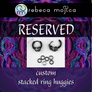 May include: Black stacked ring huggie earrings with multiple rings. The image includes the word "RESERVED" and the text "custom stacked ring huggies". The earrings are displayed on a white surface with a colorful background.