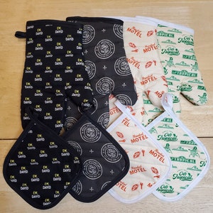 May include: Set of six oven mitts and pot holders in various patterns.  The mitts are black with a white and yellow pattern, white with a red and yellow pattern, and white with a green and yellow pattern. The pot holders are black with a white and yellow pattern, white with a red and yellow pattern, and white with a green and yellow pattern.