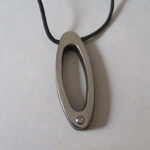Wood and steel pendant witha small diamond