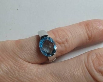 May include: A silver ring with a light blue oval-shaped gemstone.