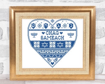 May include: A framed cross-stitch design in blue and white with a heart shape. The heart features a traditional Jewish pattern with the words "Chag Sameach" in the center.