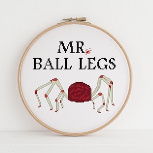May include: A white embroidery hoop with a red and white spider design and the text "MR. BALL LEGS".