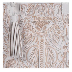 May include: White leather tote bag with an embossed floral design and the word "THERESA" in the center. The bag has a white tassel.