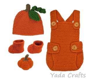May include: A crocheted pumpkin outfit for a baby, including a hat, dungarees, booties, and a small pumpkin. The outfit is orange with green leaves on the hat and brown buttons on the dungarees.