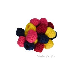 May include: A collection of crocheted balls in yellow, pink, red, and navy blue. The balls are arranged in a pile and are all the same size.