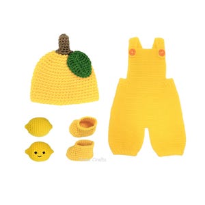 May include: A collection of handmade crochet baby items in a lemon theme. Includes a yellow lemon-shaped hat with a green leaf, a pair of yellow overalls, two lemon-shaped toys, and a pair of baby booties. The items are made of soft yarn.