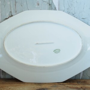 May include: White octagonal serving platter with a green and gold mark on the bottom. The mark reads "Made in France".