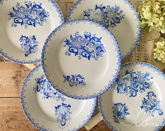 Op de afbeelding: Set van vijf blauwe en witte porseleinen borden met een decoratief ontwerp van engelen en bloemmotieven. De borden hebben een gegolfde rand en een witte achtergrond.
