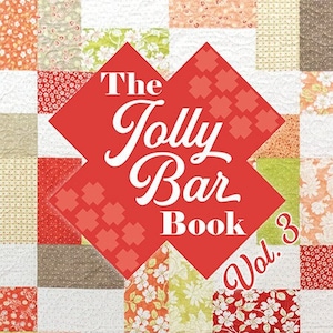 Pode incluir: O livro The Jolly Bar Book Vol. 3 apresenta 20 padrões de patchwork em um esquema de cores vermelho, branco e verde. A capa do livro apresenta um diamante vermelho com texto branco que diz "The Jolly Bar Book Vol. 3".