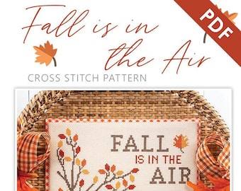 Könnte beinhalten: Kreuzstichmuster mit einem Fuchs und einem Baum mit Herbstlaub. Der Text "Fall is in the air" ist auf den Stoff gestickt. Das Muster ist in Stitch & Quarterly zu finden.