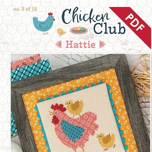 Könnte beinhalten: Kreuzstichmuster mit einer rosa Henne und zwei gelben Küken. Das Muster ist in einem Holzrahmen mit einer gelben und blauen Stoffmatte gerahmt. Der Titel des Musters ist "Hattie" und ist Teil der Serie "Chicken Club".