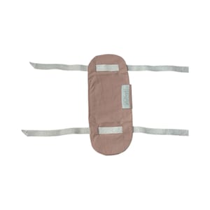 May include: A dusty rose-colored baby wrap with two silver-gray straps and a rectangular label with the text "Sterntaler". The wrap is designed to be secured around a baby.