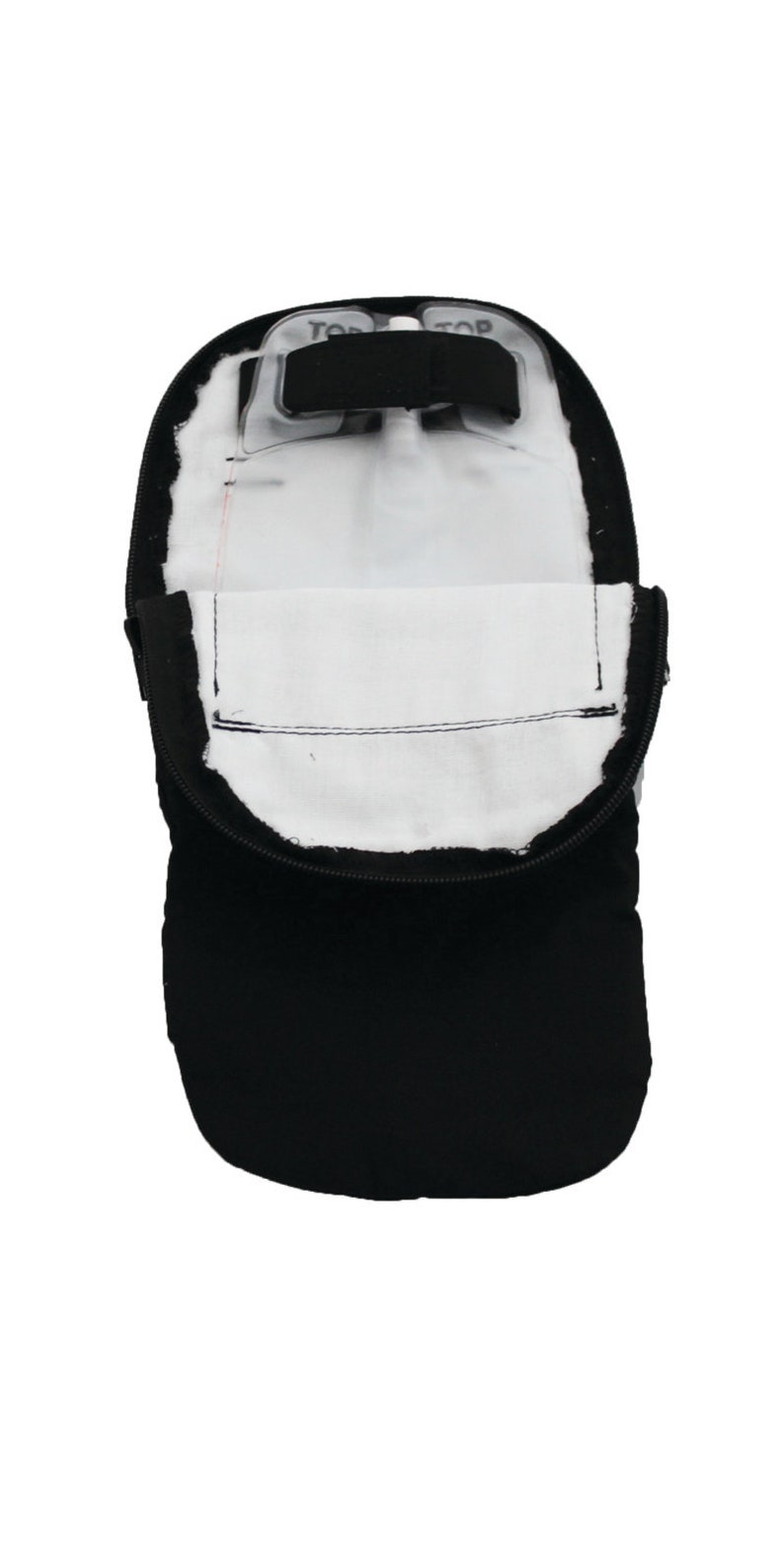 Puede incluir: Bolsa negra con cremallera, interior blanco y solapa de pl&aacute;stico transparente con la palabra "TOP" impresa.