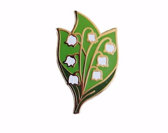 May include: A gold-toned enamel pin featuring a cluster of white lily of the valley flowers with green leaves.