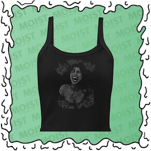 May include: A black sleeveless crop top featuring a graphic print of a person with an open mouth and distressed facial expression. The text "WHY DON'T YOU LOVE ME" is printed in a stylized, jagged font above and below the central figure.