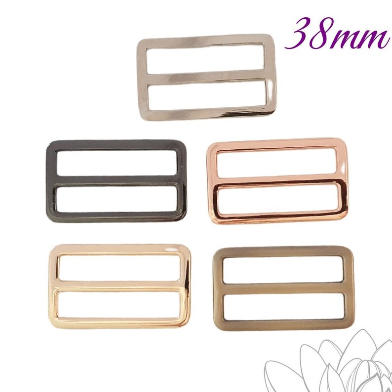 K&ouml;nnte beinhalten: F&uuml;nf rechteckige Metallschieber in verschiedenen Ausf&uuml;hrungen: Silber, Schwarz, Ros&eacute;gold, Gold und Bronze. Der Text "38mm" (3,8 cm) befindet sich oben rechts und gibt die Breite der Schieber an.