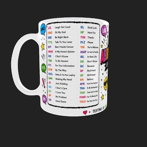 May include: A white ceramic mug featuring a list of common internet text abbreviations and their meanings printed in various colours. The design includes colourful speech bubbles, stars, a smiley face with sunglasses, and the text "TEXTING IS EASY".