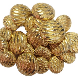 May include: A group of 16 gold-coloured buttons with a textured, woven design. The buttons are round and have a slightly raised centre.