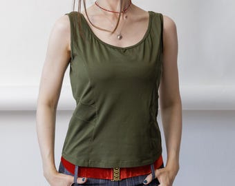 May include: An olive green sleeveless tank top with a scoop neckline and side panel detailing, paired with a bright red velvet belt featuring a gold buckle and dark blue trousers with a subtle vertical pinstripe pattern and a textured finish.