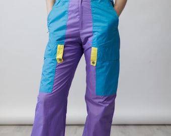 Pantalones de esquí vintage de los 80 en color lavanda y turquesa con bloques de color, paneles cargo y cierre de broches, talla S.