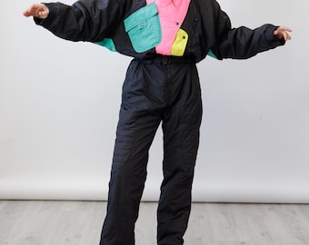Traje de esquí vintage de los 80 en negro y rosa neón con bloques de color, mono asimétrico de una pieza, talla M.