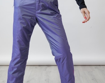Pantalones de esquí vintage de los 90 con tejido iridiscente violeta, cintura alta con cinturón y cierre de velcro en los tobillos, talla S.