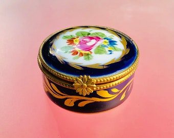 Vintage hand painted circular Limoges trinket box painted in blue and gold with floral decoration