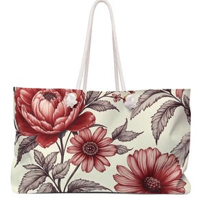 May include: A large white tote bag with red and gray floral print. The bag has white rope handles.