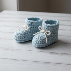 Può includere: Un paio di scarpine da neonato all'uncinetto azzurre con lacci color crema. Le scarpine fatte a mano sono realizzate in morbido filato e sono progettate per tenere al caldo i piedini del bambino. Un regalo perfetto per un neonato.