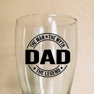 May include: A clear glass beer mug with a black vinyl sticker that reads "The Man The Myth Dad The Legend".
