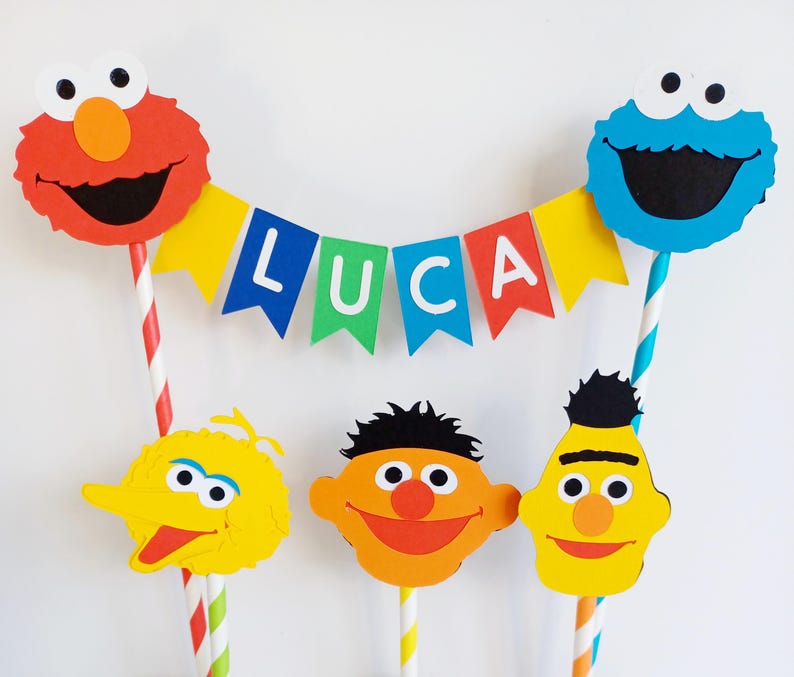 May include: A cake topper set featuring Sesame Street characters, including Elmo, Cookie Monster, Big Bird, and Bert and Ernie. The set includes a banner that reads "LUCA".