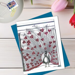 May include: A rectangular greeting card featuring a black and white ink illustration of a peacock with its tail feathers fanned out. Each feather eye is replaced by a red heart shape. The peacock stands centered against a simple architectural frame.