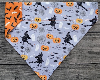 May include: A grey and orange Halloween-themed dog bandana with a pattern of witches, ghosts, pumpkins, bats, spiders, and the word "Boo!" repeated throughout.