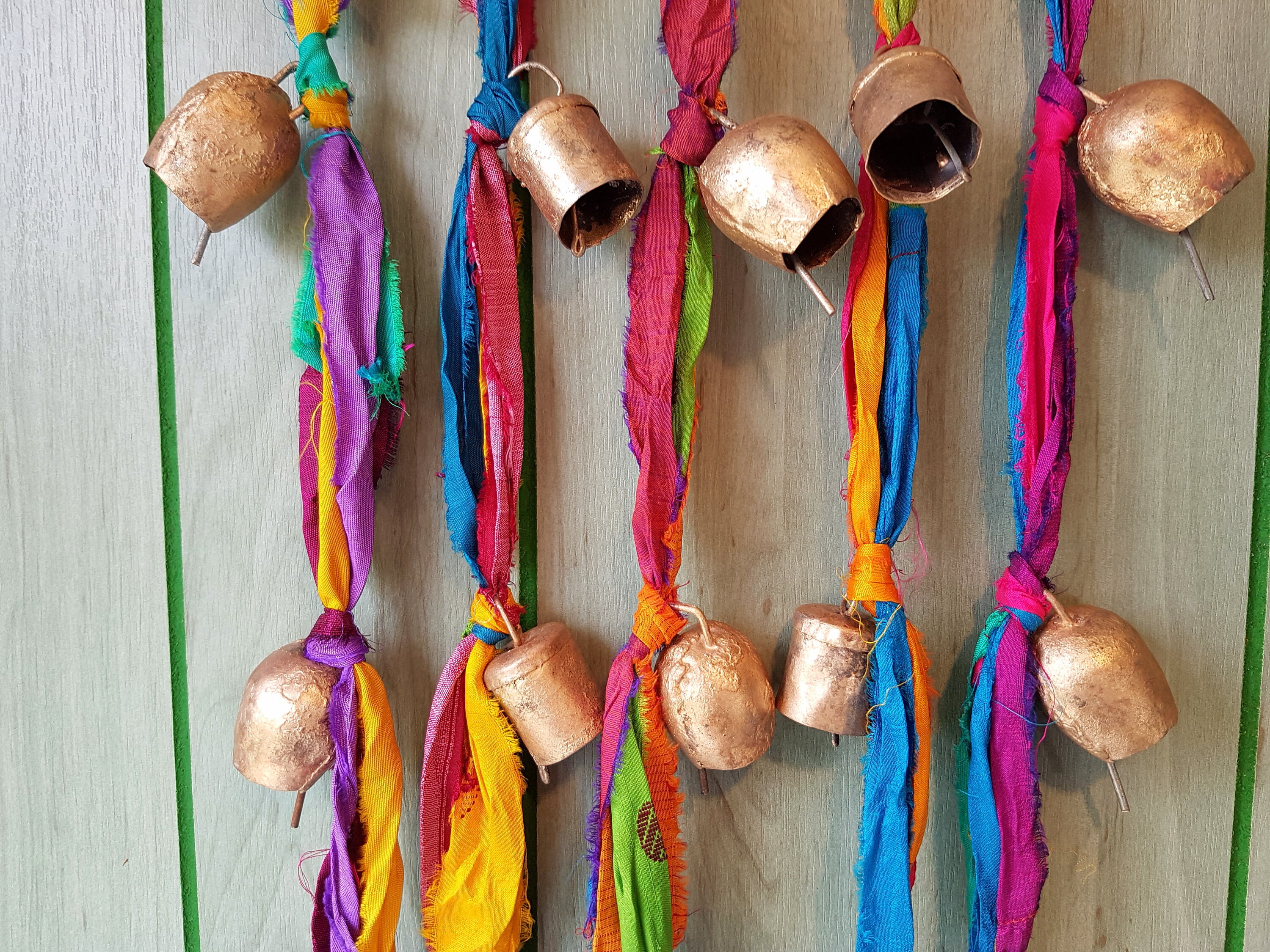 Un Carillon avec 3 Cordes de Ruban Soie Sari Multicolore et Cloches Vache en Métal Rustique Couleur